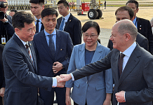 German Chancellor Olaf Scholz shakes hands with Chinese Ambassador to Germany Wu Ken next to Chongqing Vice Mayor Zhang Guozhi, upon arriving at the airport in Chongqing, China | Reuters/Andreas Rinke