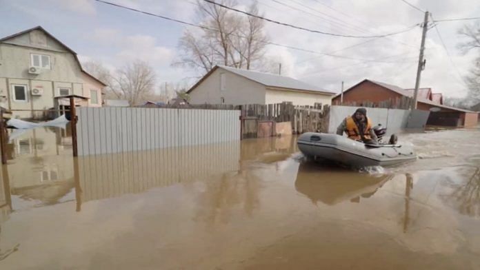 A man rides a boat in a flooded street in Orenburg, Russia, in this still image taken from video released April 8, 2024. Mayor of Orenburg City Sergei Salmin via Telegram/Handout via REUTERS