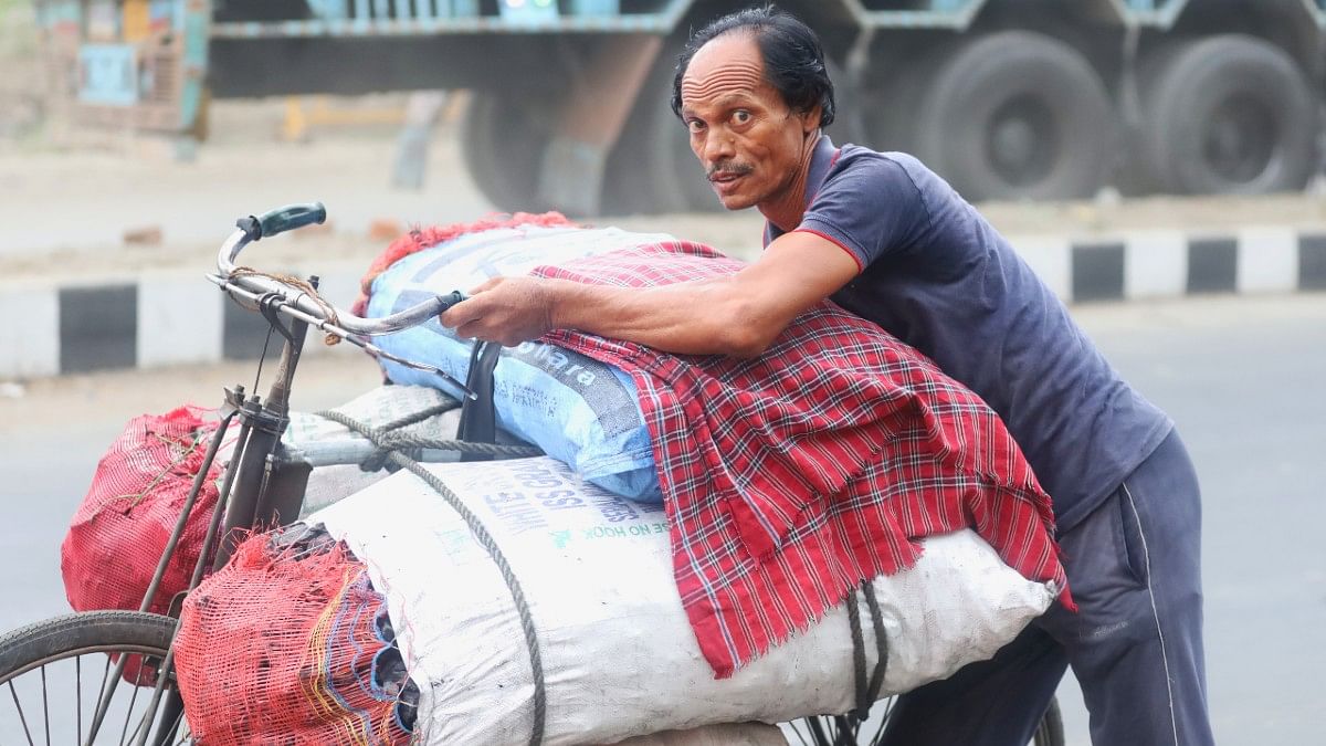 A man carrying coal-filled gunny bag on his cycle | Manisha Mondal | ThePrint