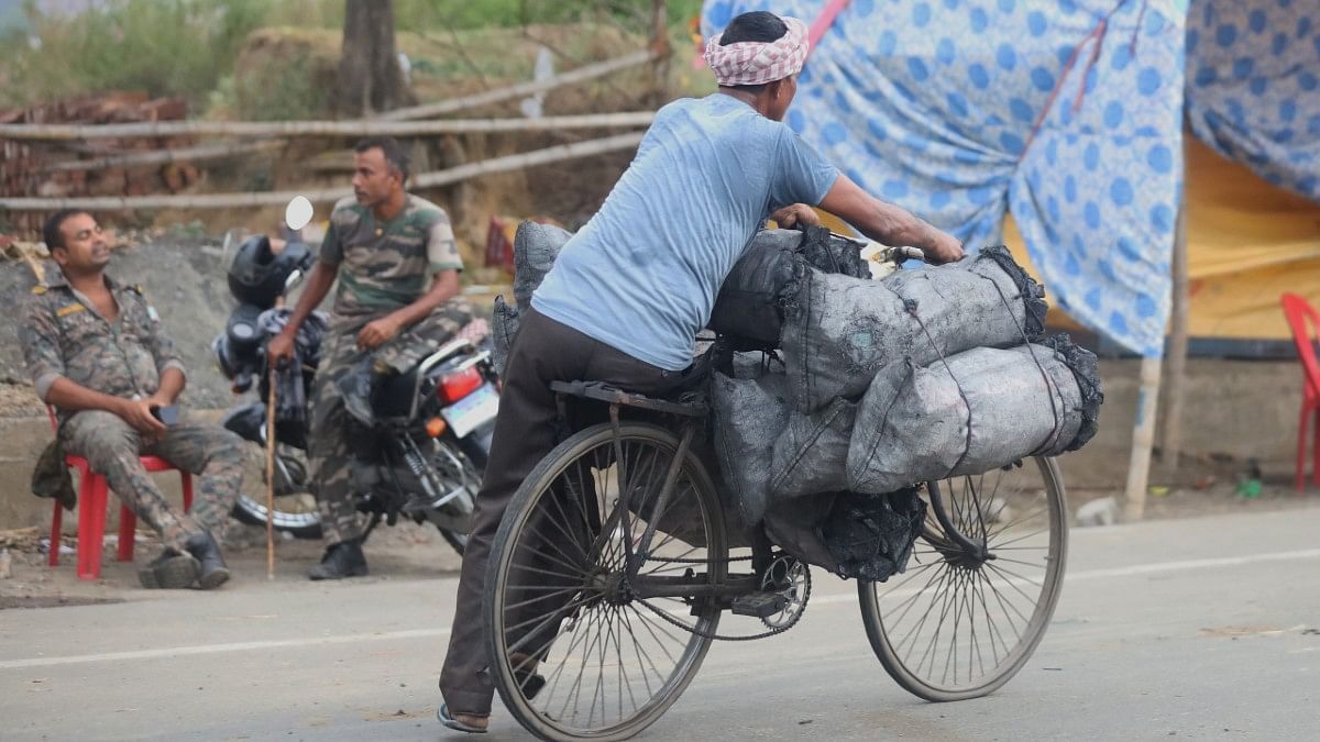 A man hauling gunny bags filled with coal on his cycle | Manisha Mondal | ThePrint