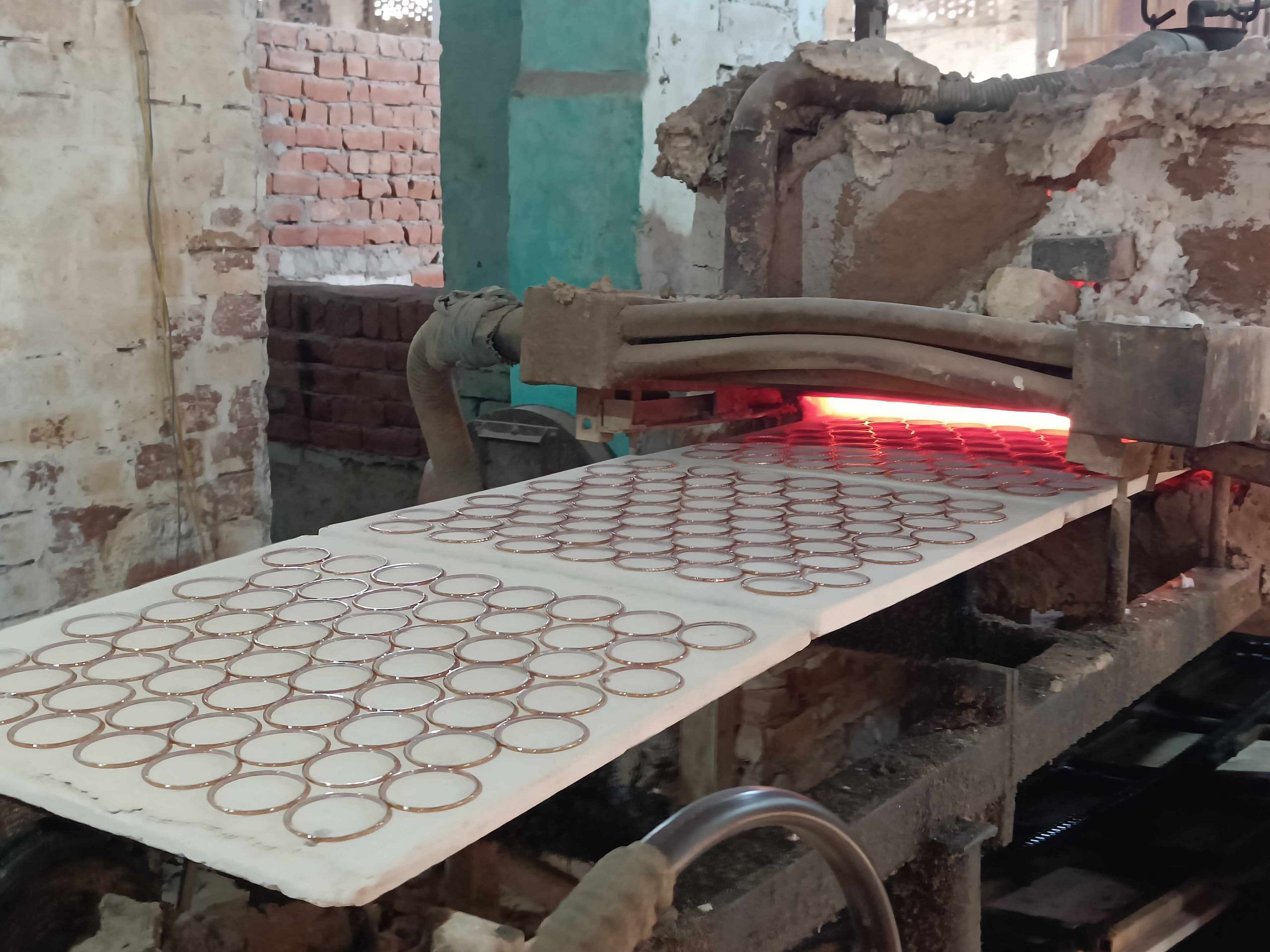 Glass bangles pass through a machine at Saubhagya Glass Factory | Krishan Murari | ThePrint 
