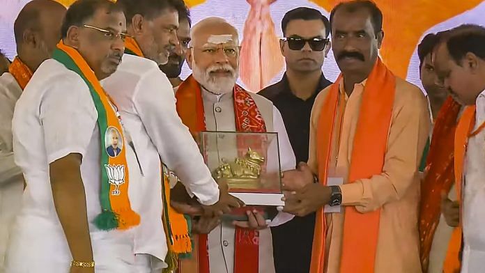 Prime Minister Narendra Modi being presented a memento during a public meeting for Lok Sabha polls, in Karimnagar, Wednesday | PTI Photo