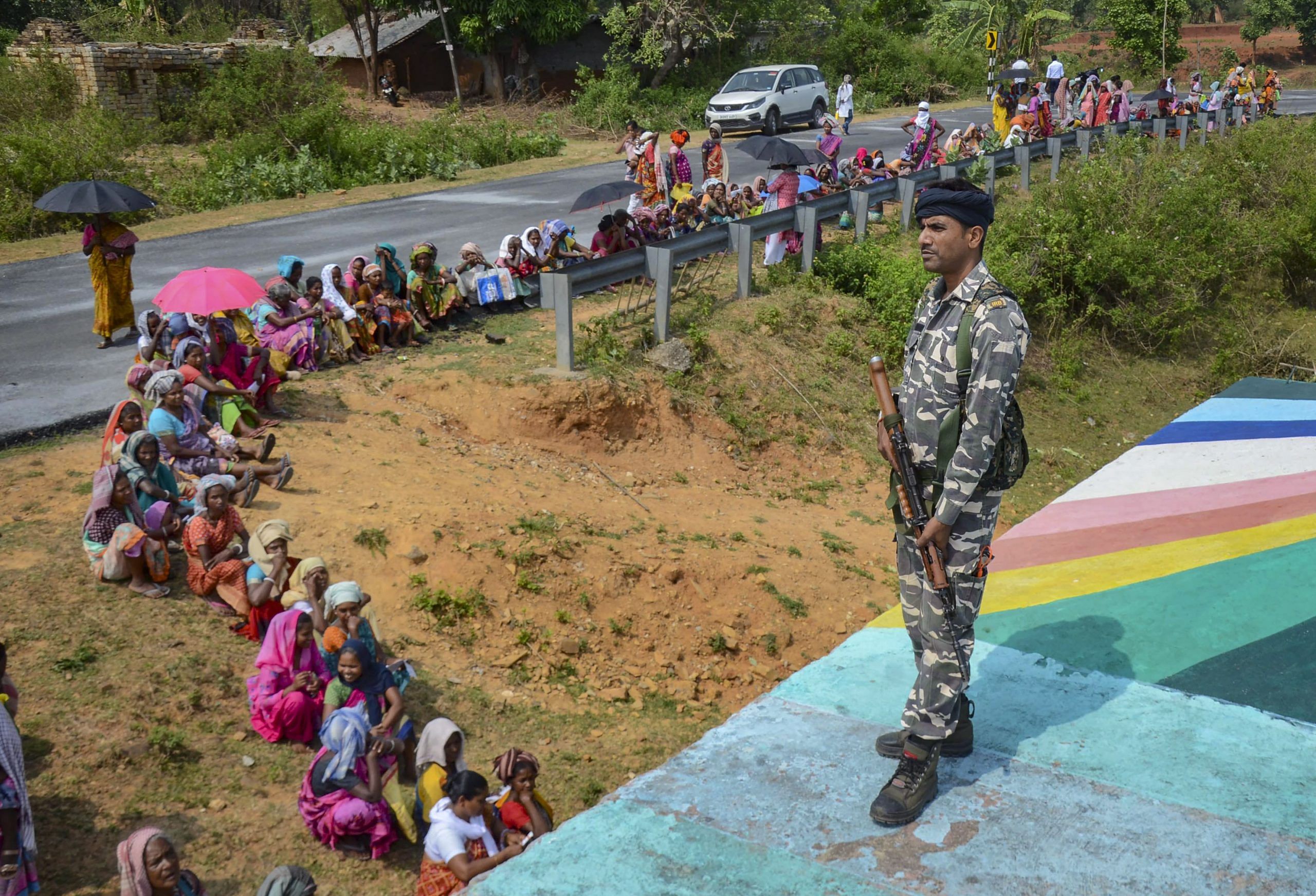 A security personnel keeps vigil as people wait to cast their vote during the fourth phase of Lok Sabha elections, in Khunti district, Monday, May 13, 2024 | PTI