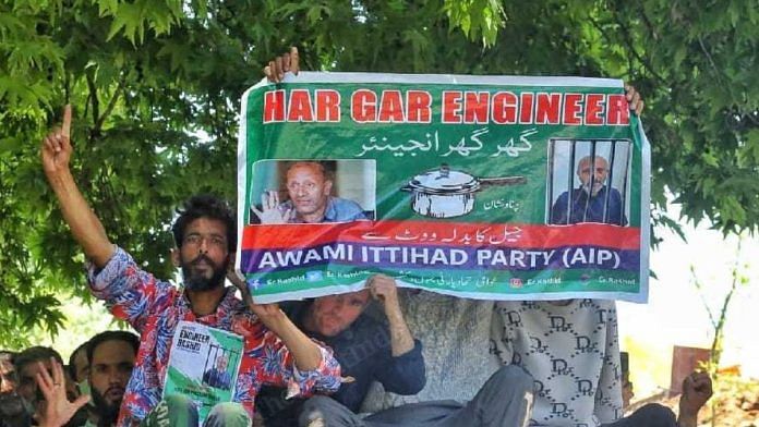 Supporters hold up posters featuring photos of Sheikh Abdul Rashid, or ‘Engineer Rashid’, at a roadshow Baramulla | Praveen Jain | ThePrint