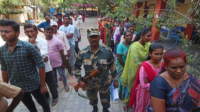 Security personnel stand guard as voters wait in queues to cast their votes at a polling booth in Sullurupeta, Tirupati | ANI