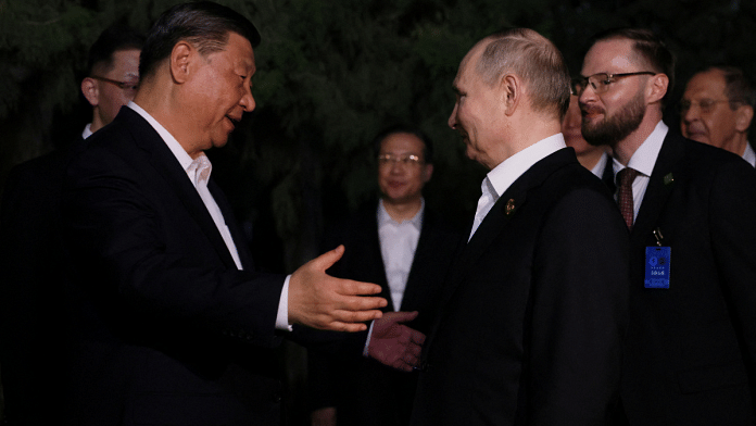 Russian President Vladimir Putin and Chinese President Xi Jinping bid farewell Friday at the end of talks in Beijing | Sputnik/Mikhail Metzel/Pool via REUTERS