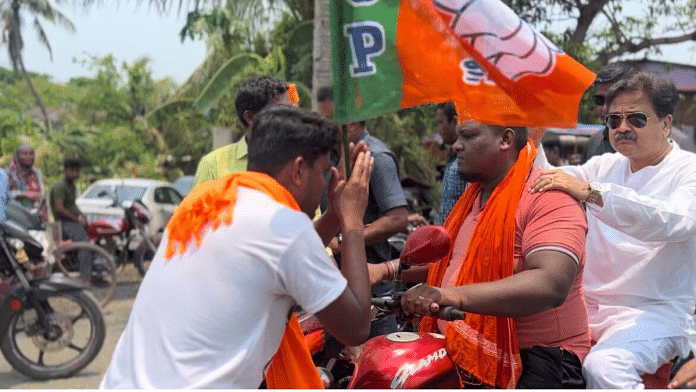BJP candidate Abhijit Gangopadhyay is greeted by a supporter during his campaign in Tamluk | Sreyashi Dey | ThePrint