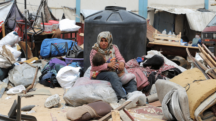 A woman sits with a child, on the day Palestinians travel on foot along with their belongings, as they flee Rafah due to an Israeli military operation, in Rafah, in the southern Gaza Strip, May 28, 2024. Reuters | Hatem Khaled