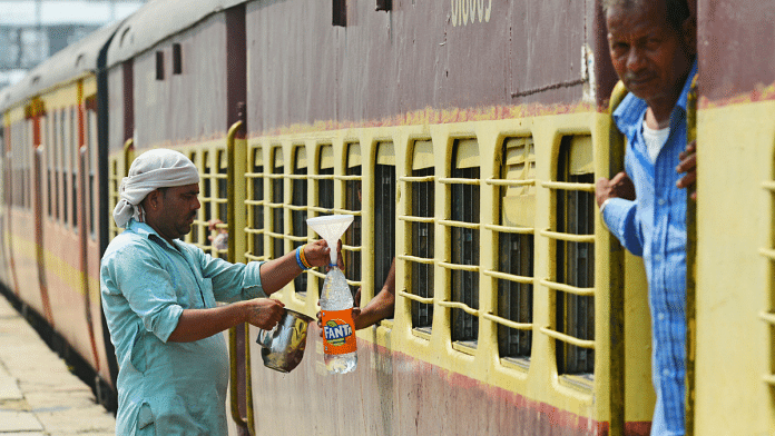 A volunteer serves cold water to the passengers onboard a train on a hot summer day, at a railway station in Jalandhar | ANI photo
