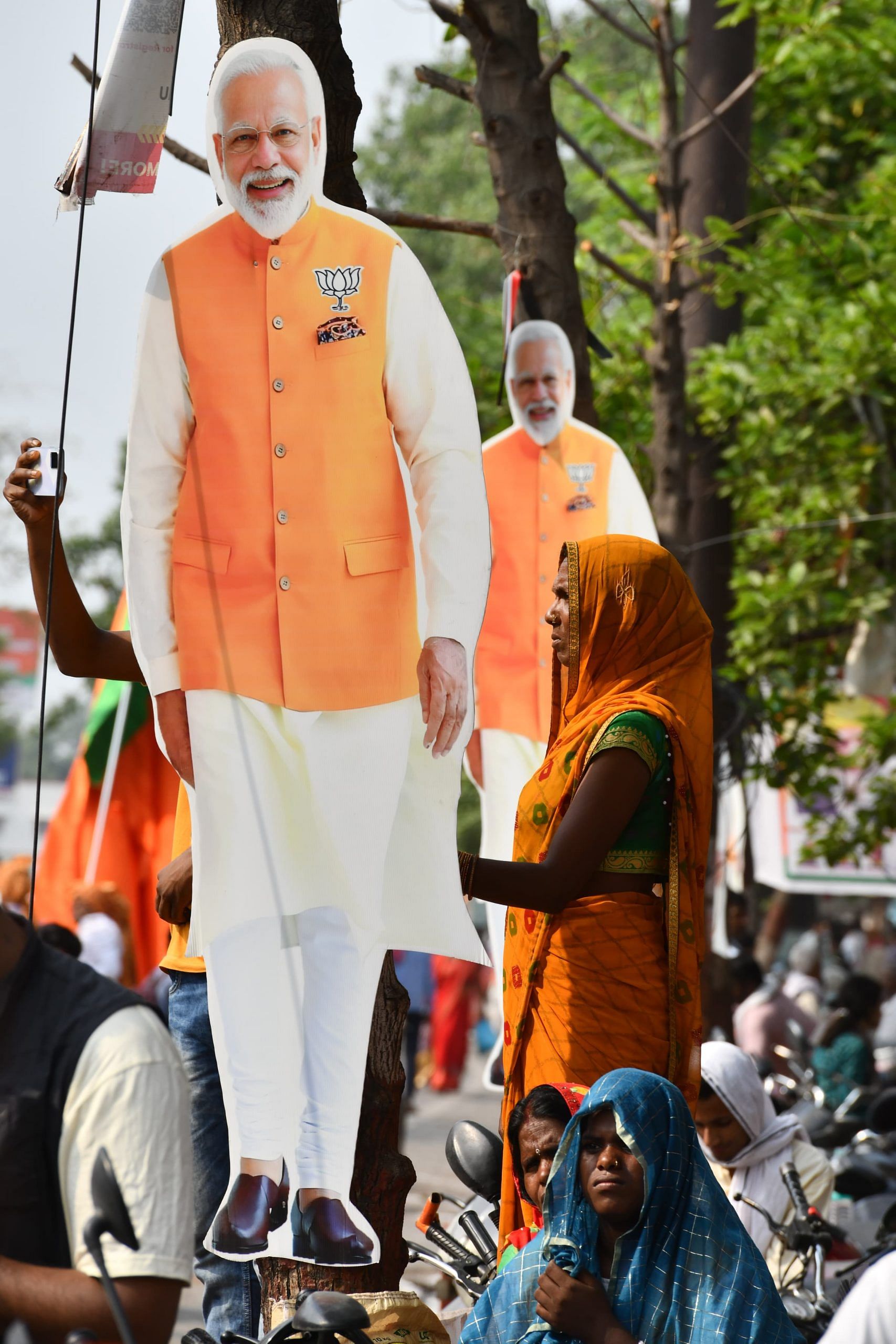A woman supporter by the Modi billboard, observing the roadshow | Suraj Singh Bisht | ThePrint