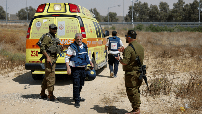 Israeli soldiers and medics walk near an ambulance after Palestinian Islamist group Hamas claimed responsibility for an attack on Kerem Shalom crossing, near Israel's border with Gaza in southern Israel, 5 May, 2024 | Reuters/Amir Cohen