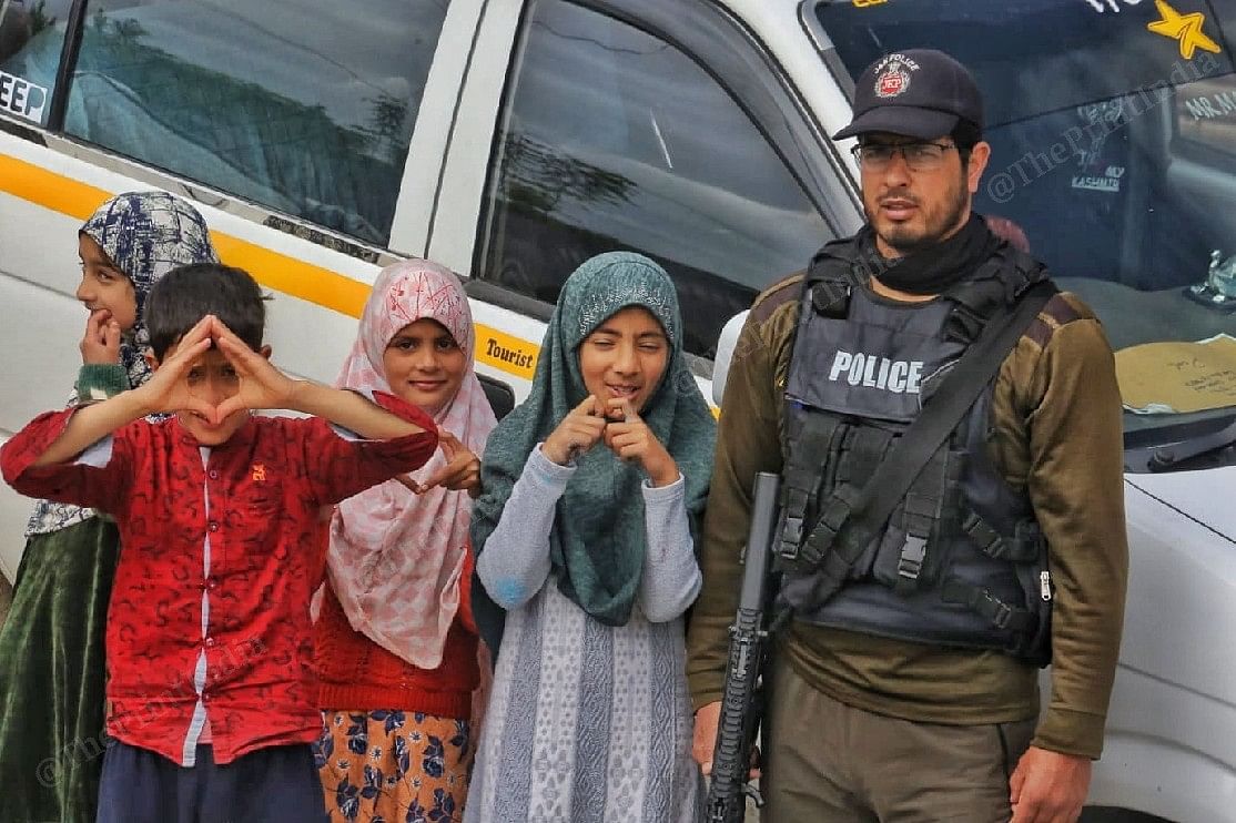 Children pose for the camera outside a polling station in Pulwama | Praveen Jain | ThePrint