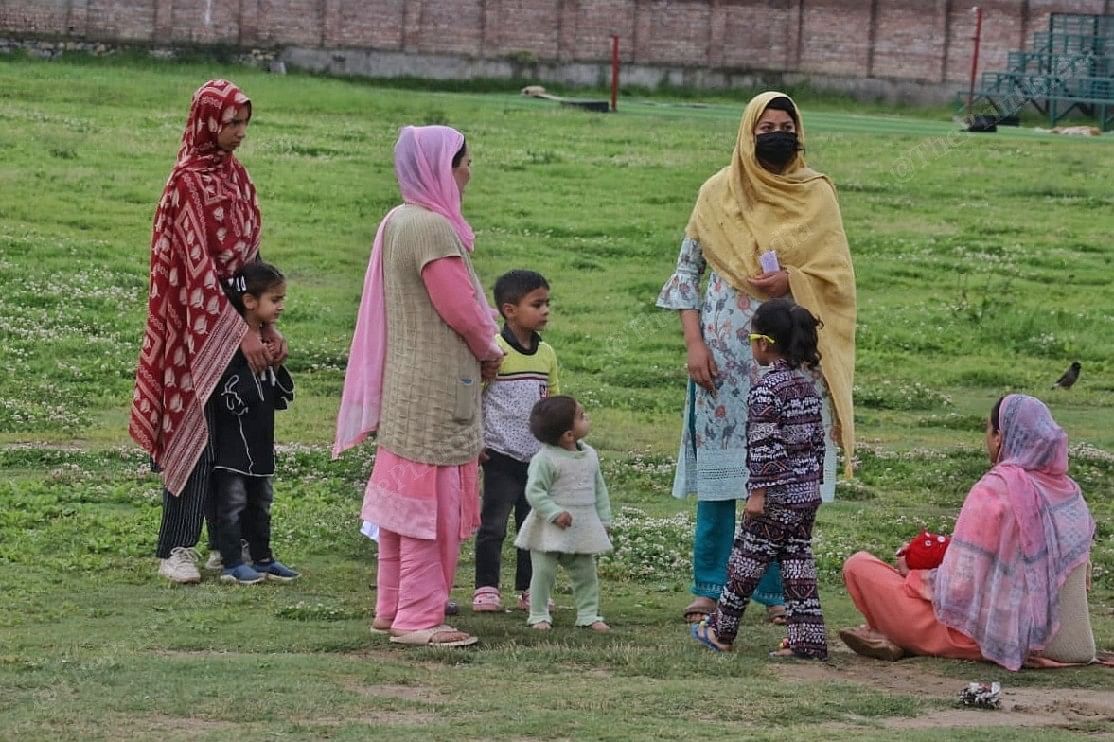 Women voters feeding their children in an open area near a polling booth | Praveen Jain | ThePrint