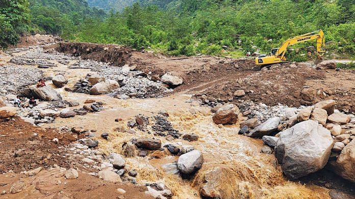 An excavator clears the debris as restoration work is underway following a landslide due to incessant rainfall, in Nepal's Taplejung on 14 June | ANI Photo