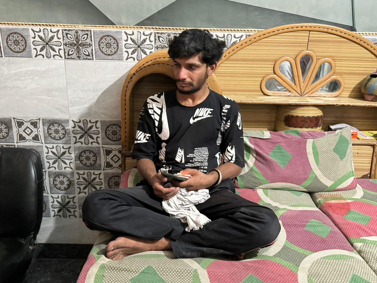 Anil Rajput (24) sits on the corner of the bed where his wife Komal was sitting moments before she was killed.