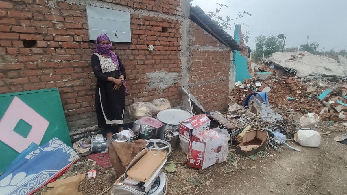 Asiya Bi standing next to items recovered from debris of her demolished house | Iram Siddique | ThePrint