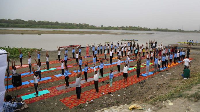 People perform yoga on the occasion of 10th International Yoga Day at Yamuna Ghat in New Delhi on Friday | ThePrint/Suraj Singh Bisht