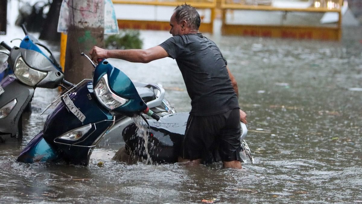 A commuter wading through a waterlogged street | Suraj Singh Bisht | ThePrint