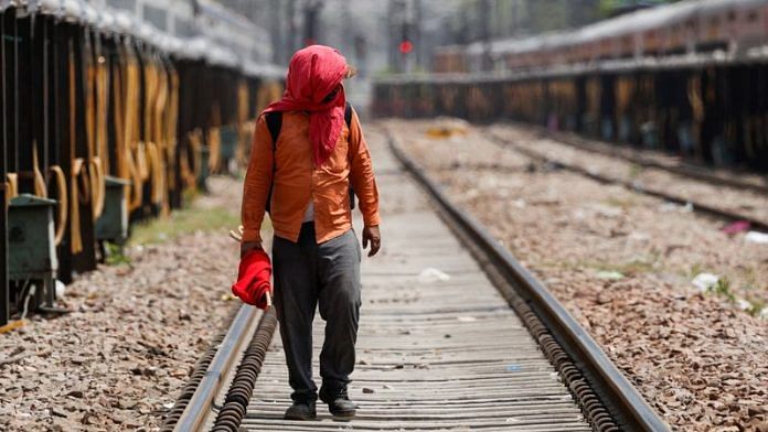 A man covers his face using a cloth to shield himself from the sun during a hot summer day in New Delhi on 18 June | REUTERS/Priyanshu Singh