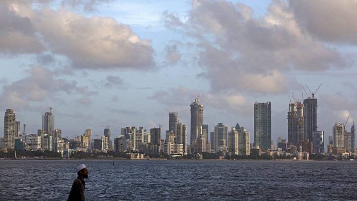 A man walks at the seafront as scattered clouds are seen over Mumbai's skyline, India, June 10, 2015. REUTERS/Danish Siddiqui/File Photo