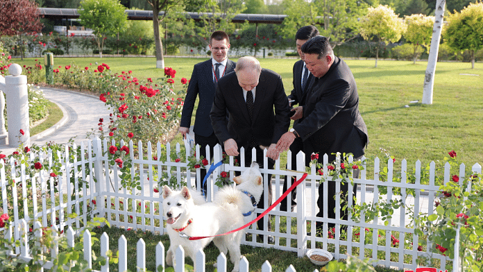 Russia's President Vladimir Putin and North Korea's leader Kim Jong Un pet dogs during a walk in the garden of the Kumsusan Guesthouse in Pyongyang, North Korea in this image released by the Korean Central News Agency June 20, 2024. KCNA via REUTERS