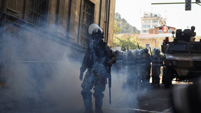 A member of the military police walks amid tear gas as Bolivia's President Arce 'denounced the irregular mobilization' of some units of the country's army, in La Paz, Bolivia on 26 June 2024 | Reuters | Claudia Morales