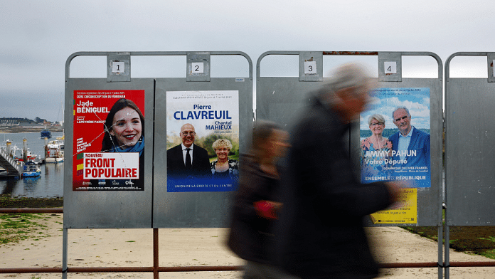 People walk past campaign posters on election boards ahead of snap elections in France | Reuters/Sarah Meyssonnier