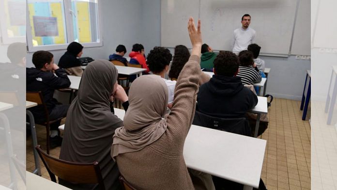 A middle school student wearing a hijab raises her hand during an Islamic ethics class at the Averroes school | File photo | Reuters/Ardee Napolitano