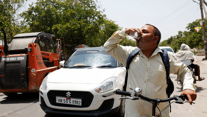 A man drinks a cooling drink offered by locals on a hot summer day during a heatwave in Narela, New Delhi, India. Reuters /Priyanshu Singh