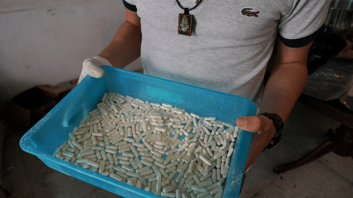 A member of Sinaloa Cartel shows capsules with methamphetamine at a safe house in Culiacan, Mexico | Reuters File Photo