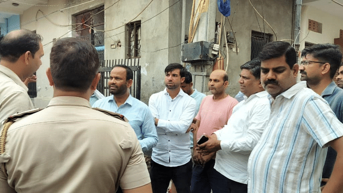 Sangam Vihar MLA Dinesh Mohaniya with policemen and local residents during his visit to the locality where tension persists | Pic credit: Facebook/Dinesh Mohaniya