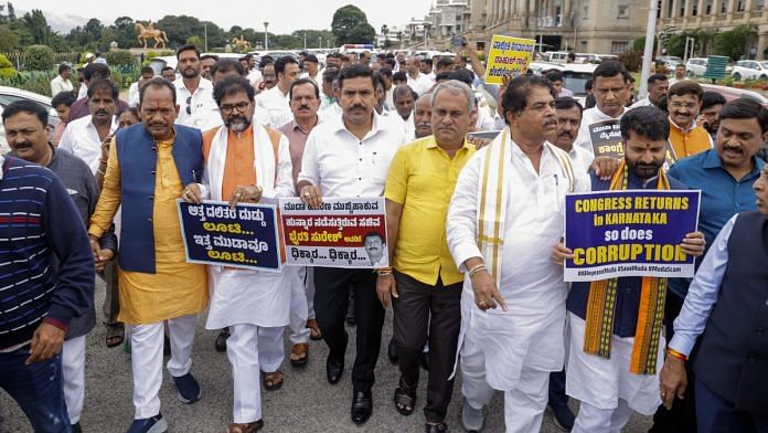 Leader of Opposition in Karnataka Assembly R Ashok with Bharatiya Janata Party (BJP) State President B Y Vijayendra and party MLAs stage a march from Vidhana Soudha to Raj Bhavan to hand against state government over the alleged scams, in Bengaluru on Thursday. | ANI
