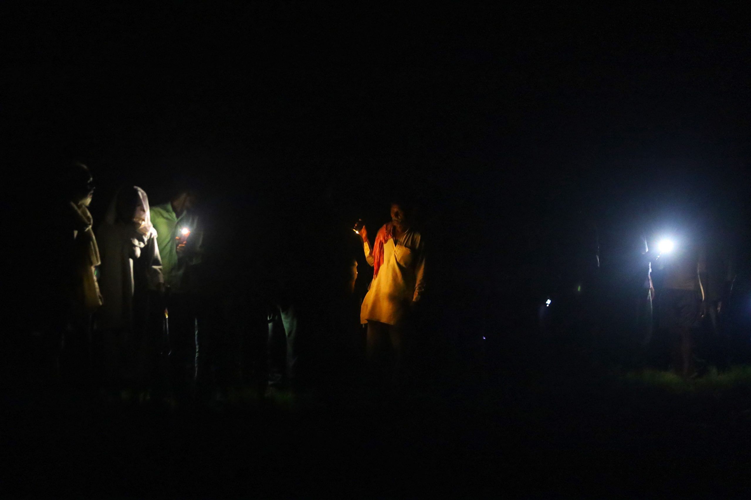 Relatives and neighbours hold up torches, candles, and mobile phones during final rites | Manisha Mondal | ThePrint