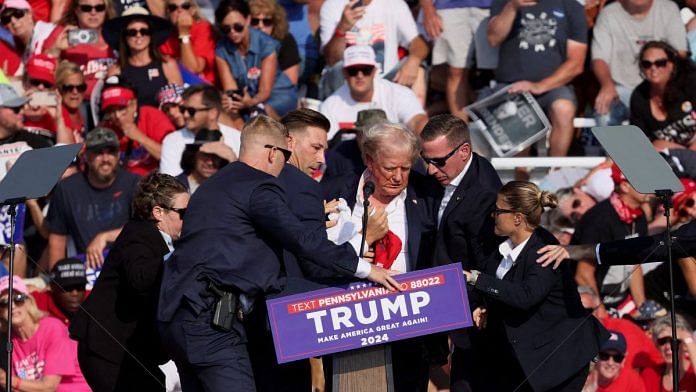 Former US president and 2024 presidential candidate Donald Trump being assisted by US Secret Service personnel after he was shot at during a rally Saturday | Reuters