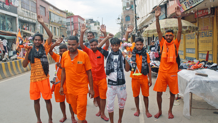 Kanwariyas carry pots filled with water from Ganga river during their annual Kanwar Yatra in Varanasi I ANI