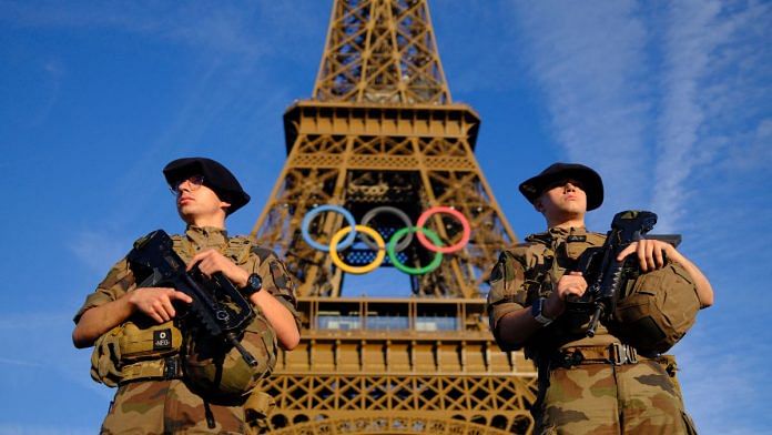 Soldiers patrol on a street in front of the Eiffel Tower ahead of the Olympics REUTERS/Stefan Wermuth