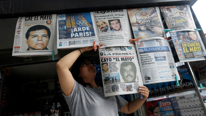 A newspaper seller arranges newspapers reporting the El Paso, Texas, U.S., arrest of Mexican drug lord Ismael 