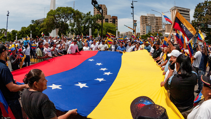 People carry Venezuela's national flag to protest the election results that awarded Venezuela's President Nicolas Maduro with a third term, in Maracaibo, Venezuela | Isaac Urrutia | Reuters