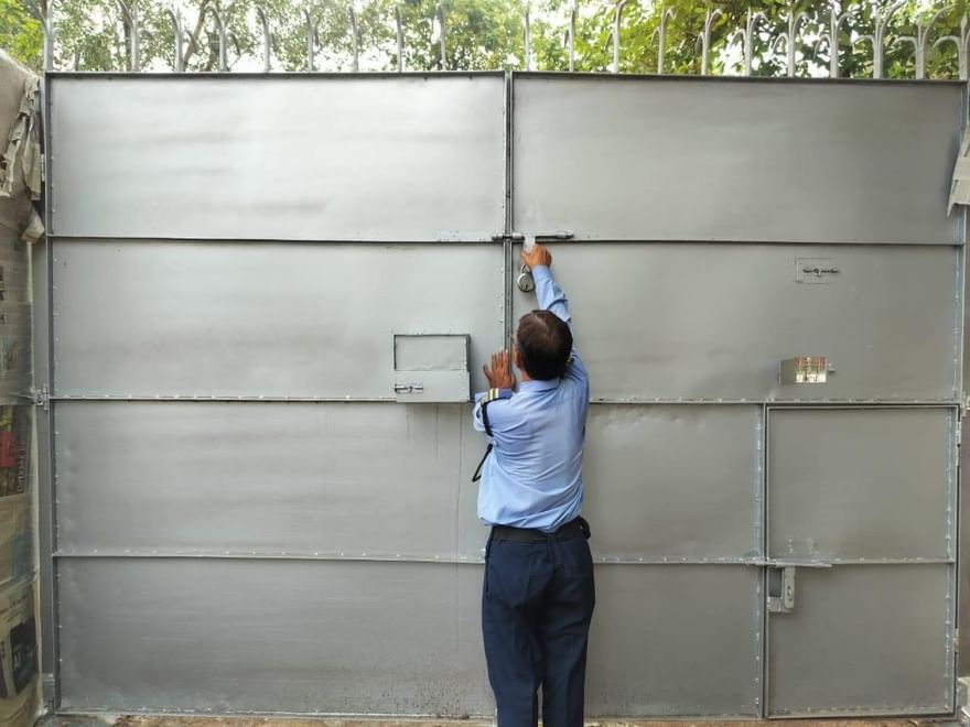 सेंट्रल दिल्ली में एक सिक्योरिटी गार्ड सुनिश्चित करते हुए कि हवेली का गेट ठीक से बंद हो | फोटो: शुभांगी मिश्रा/दिप्रिंट