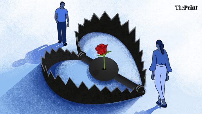 A woman and a man stand on opposite sides of a heart-shaped trap, which has a rose in the centre.