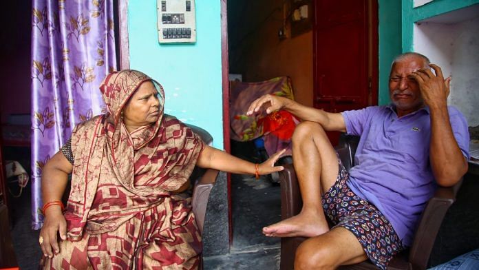 A crying Ramsevak Dikshit is comforted by his wife Radha Rani at their home in Hathras | Manisha Mondal | ThePrint