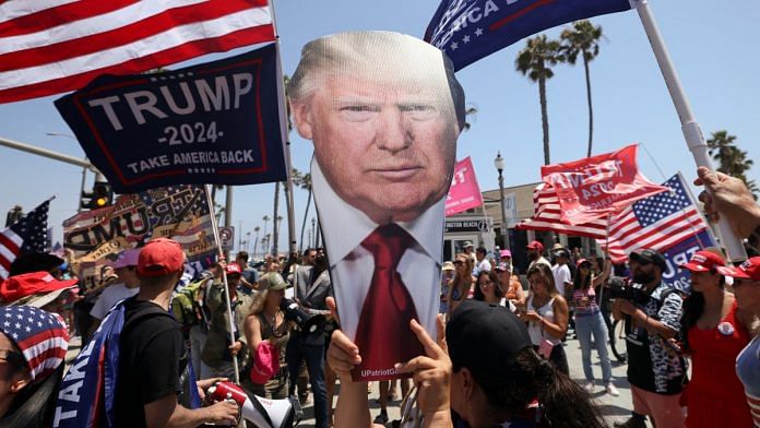 A pro-Trump supporter holds a portrait of former President Donald Trump during a demonstration in support of former U.S. President Donald Trump who was shot the previous day in an assassination attempt during a rally in Pennsylvania, in Huntington Beach, California, U.S. July 14, 2024 | Reuters