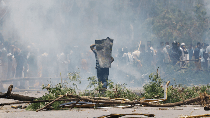 A protester covers himself with a metal sheet during a clash with Border Guard Bangladesh (BGB) and the police outside the state-owned Bangladesh Television as violence erupts across the country after anti-quota protests by students, in Dhaka, Bangladesh, 19 July, 2024 | Reuters/Mohammad Ponir Hossain/File Photo