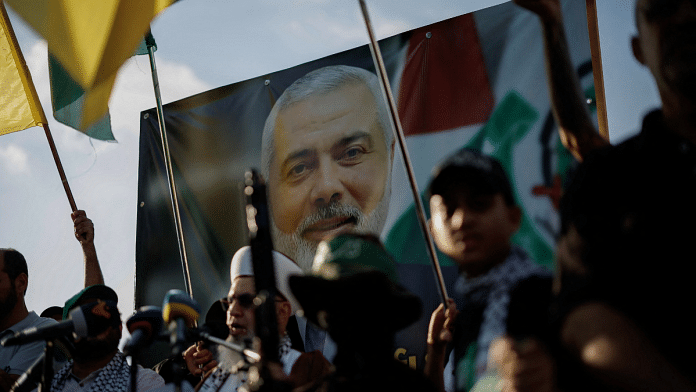 Demonstrators hold flags and weapons next to an image of late Hamas leader Ismail Haniyeh, during a protest to condemn his assassination in Iran, in Sidon, Lebanon, July 31, 2024 | Reuters/Alkis Konstantinidis/File Photo