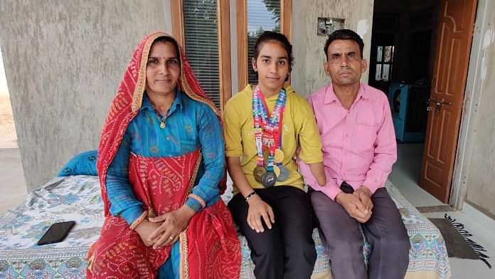 Gold medalist runner Tanisha Bajia with her parents, Bhanwari Devi and Indraj Bajia at their house in Agloi, Sikar