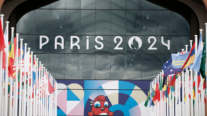 Paris 2024 Olympics logo is seen along with mascot Olympic Phryge on a building in the Olympic village | Reuters