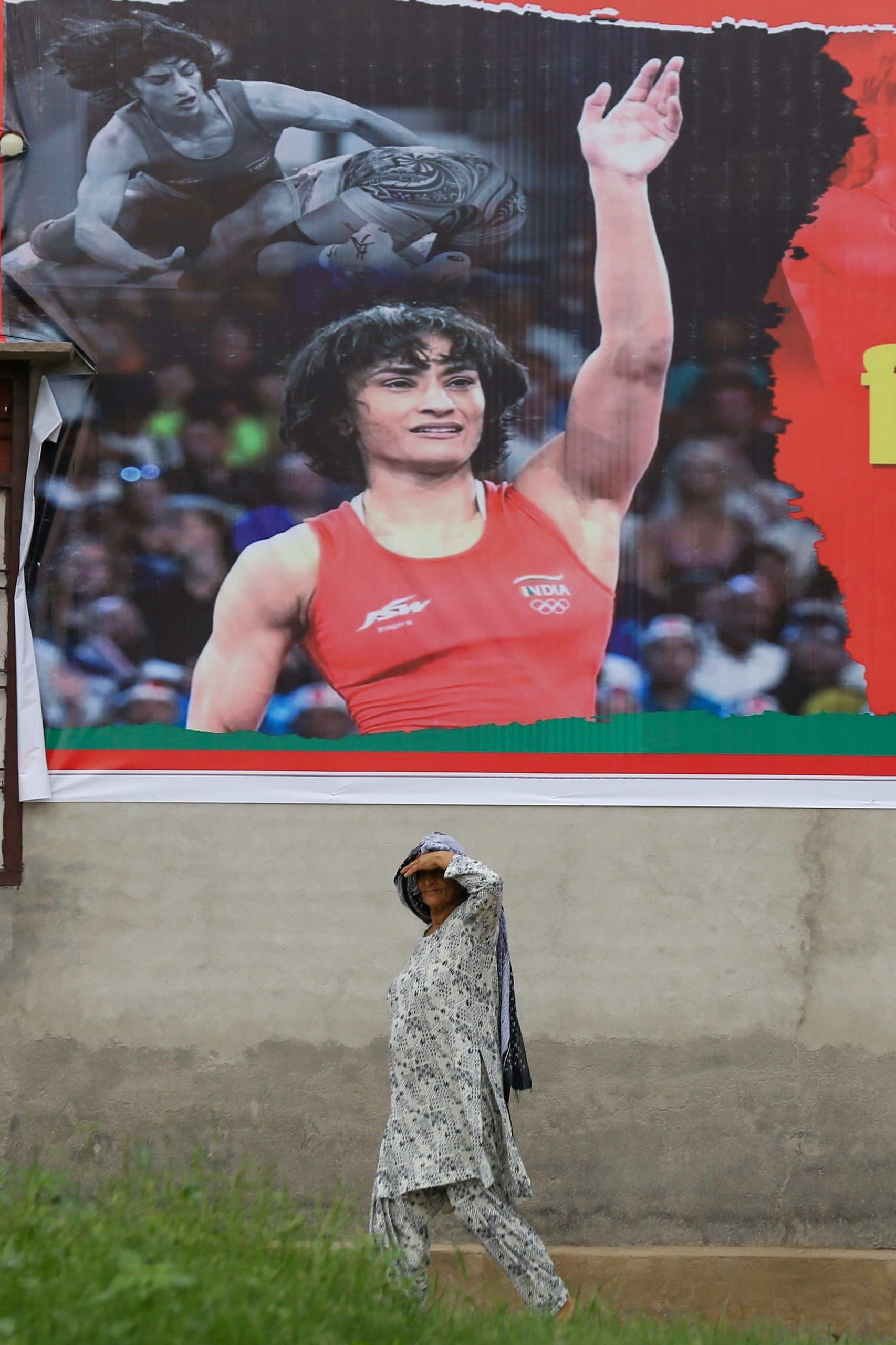 A woman walks past a poster of Vinesh Phogat | Photo: Suraj Singh Bisht | ThePrint