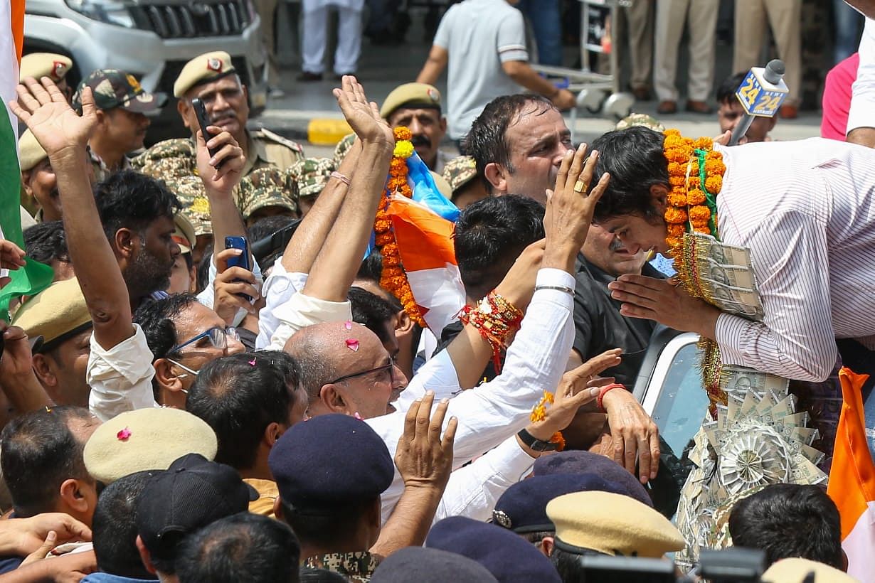 People gathered at the airport bless Vinesh Phogat | Photo: Suraj SIngh Bisht | ThePrint