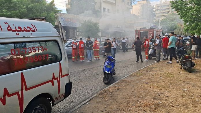 Smoke rises from a mobile shop as civil defence members gather in Sidon, Lebanon | Reuters/Hassan Hankir