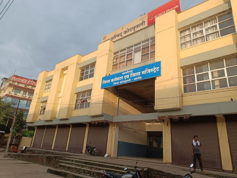 कोटपुतली जिला कलेक्ट्रेट, जो अस्थायी रूप से पीले रंग की नगर परिषद की इमारत में स्थित है, प्रशासनिक पावर की उस सीट से बहुत दूर है, जो इसे होना चाहिए था. इमारत के दोनों कोनों में नाई की दुकानें हैं. राजस्थान के कई नए बने जिलों में भी यही कहानी है | फोटो: कृष्ण मुरारी/दिप्रिंट